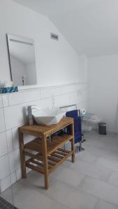 a bathroom with a white sink and a mirror at Ferienwohnung Krabbe im Haus-Neuharlingersiel in Neuharlingersiel