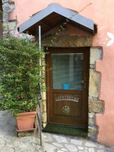 a door to a pink building with a potted plant at New Arcobaleno Ossegna in Maissana