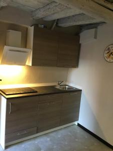 a kitchen with brown cabinets and a sink at New Arcobaleno Ossegna in Maissana