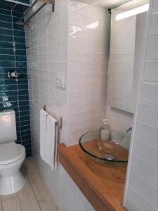 W łazience znajduje się szklana umywalka i toaleta. w obiekcie Lisbon Castle Apartment w Lizbonie