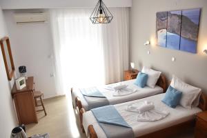 um quarto com 2 camas e uma janela em Ephelia gold em Laganas