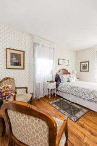 1 dormitorio con 1 cama, mesa y sillas en Willow House Inn B&B, en Pictou