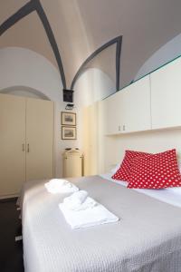 a bedroom with a white bed with red pillows at La Casa delle Volte in La Spezia