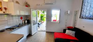 una cucina con divano rosso in una camera di Apartments Marita a Ston (Stagno)