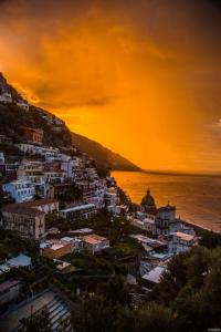 a view of a city at sunset with the ocean at Boutique by the Sea in Positano