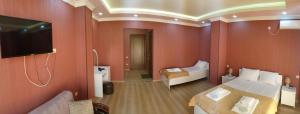 Habitación de hotel con 2 camas y TV de pantalla plana. en Hotel BellMar, en Kobuleti