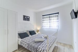 a white bedroom with a large bed with blue pillows at LOVELY APARTMENTS Senj - Spectacular Sea View & Free Parking & WI-FI in Senj