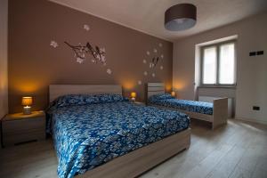 a bedroom with two beds with blue comforter at Casa Nonna Ida - Vacanze in Langa in Santo Stefano Belbo