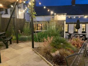 un jardín por la noche con luces y un patio en The White Hart, en Llantwit Major