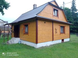 a small wooden cabin with a gambrel roof at Садиба Брусний in Mykulychyn