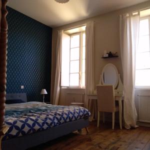 um quarto com uma cama, uma secretária e janelas em Appartement spacieux de 100m2 à deux pas du centre ville de Carcassonne em Carcassonne