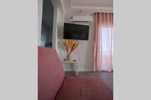 360° View Suites Sin في نيابوليس: غرفة معيشة مع أريكة حمراء وتلفزيون