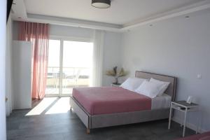 1 dormitorio con cama y ventana grande en 360° View Suites Sin en Neapolis