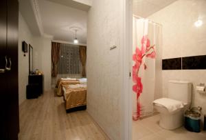a bathroom with a room with two beds and a toilet at Golden Horn Life Hotel in Istanbul