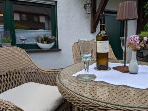 - une bouteille de vin assise sur une table avec un verre dans l'établissement Ferienwohnung Am Waldweg, à Kaisersesch