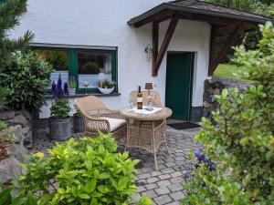 a patio with a table with a bottle of wine at Ferienwohnung Am Waldweg in Kaisersesch