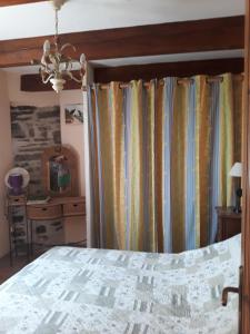 a bedroom with a bed and a curtain at le vieux mas du domaine de Pontet-Fronzele in Lagorce