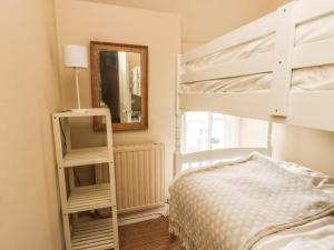 a bedroom with a bunk bed and a mirror at Silva in Penmon