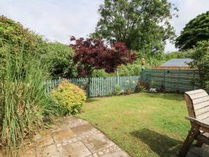 a garden with a fence and a bench at Silva in Penmon