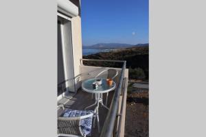 a balcony with a table and a view of the ocean at 360° View Suites Tan in Neapoli Voion +11 photos