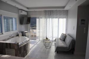 a large bathroom with a tub and a couch and a couch at 360° View Suites Tan in Neapoli Voion