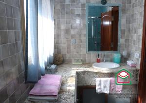ein Bad mit einem Waschbecken und einem Spiegel in der Unterkunft Casa Mia in Ouled Kacem