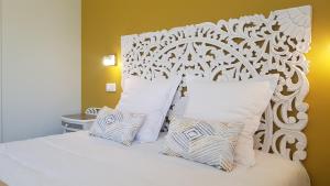 une chambre avec un lit blanc avec des oreillers blancs dans l'établissement Domaine de Keryargon, Chambres d'hôtes B&B et Location de Vacances, à Belz