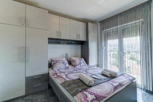 Un dormitorio con una cama grande con una ventana grande. en Lovely Apartments Senj, en Senj
