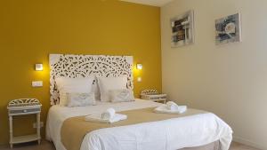 une chambre avec un lit blanc avec deux serviettes dessus dans l'établissement Domaine de Keryargon, Chambres d'hôtes B&B et Location de Vacances, à Belz