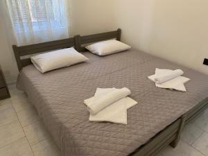 a bed with white pillows on top of it at Casa Plakes in Ermoupoli