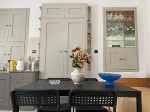 a kitchen with a table with a vase of flowers on it at Casa Plakes in Ermoupoli