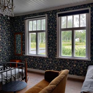 a living room with two windows and a couch at Willa Viktor in Kristiinankaupunki