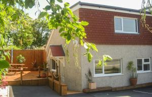 a house with a patio and a wooden fence at Chynoweth Mews in Newquay