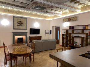 een woonkamer met een bank, een tafel en een open haard bij Palazzo Forlani in Capranica