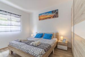 a bedroom with a large bed with blue pillows at LOVELY APARTMENTS Senj - Spectacular Sea View & Free Parking & WI-FI in Senj +50 photos