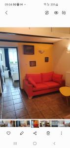 a living room with a red couch and a table at Przytulny apartament-cosy and beautiful in Żywiec
