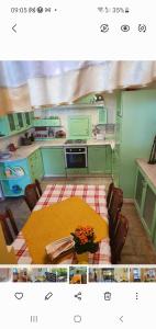 a kitchen with a table and a kitchen with green cabinets at Przytulny apartament-cosy and beautiful in Żywiec
