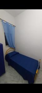 a bedroom with a blue bed with a blue curtain at Marina di Girgenti in Porto Empedocle