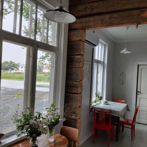 a dining room with a table and some windows at Willa Viktor in Kristiinankaupunki