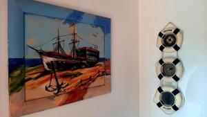 una pintura de un barco en una pared junto a un reloj en Adri Guest House, en Nesebar