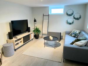 uma sala de estar com um sofá e uma televisão de ecrã plano em Two bedroom apartment near the city centre. em Tromsø