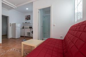 een woonkamer met een rode bank en een keuken bij Apartment La Gitanilla terrace in Cádiz