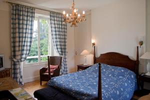 a bedroom with a bed and a window and a chandelier at Chambres d'hôtes Les Pratges in Figeac