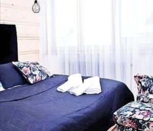 a blue bed with two pillows on top of it at Otuleni Tatrami Apartments in Kościelisko