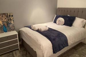a bedroom with a bed with blue and white sheets at Modern stylish flat over garage in Crewe