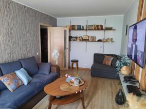a living room with a blue couch and a table at Cosy home 10 min from city center in Tallinn