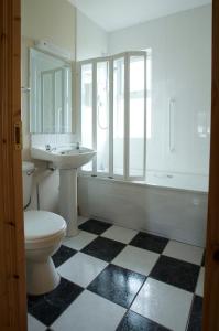 een badkamer met een toilet, een wastafel en een raam bij Cliff Cottages in Liscannor