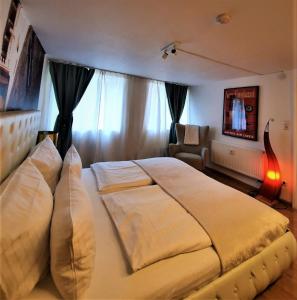 a bedroom with a large white bed and a chair at Design Apartment BarcelonaNights in Freiburg im Breisgau