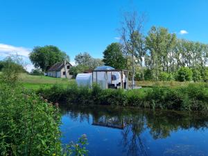 un kiosque au bord d'une rivière dans l'établissement domaine des butineuses, à Marchainville