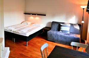 LidöにあるLidö Värdshusのベッド1台とソファが備わる小さな客室です。